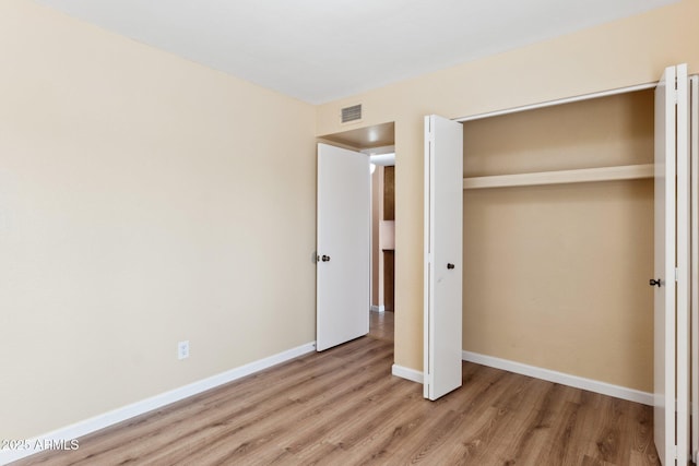 unfurnished bedroom featuring light hardwood / wood-style floors and a closet