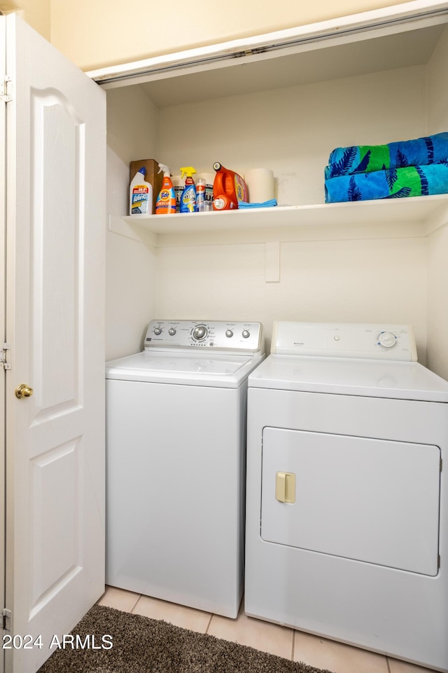 clothes washing area featuring laundry area, independent washer and dryer, and light tile patterned floors