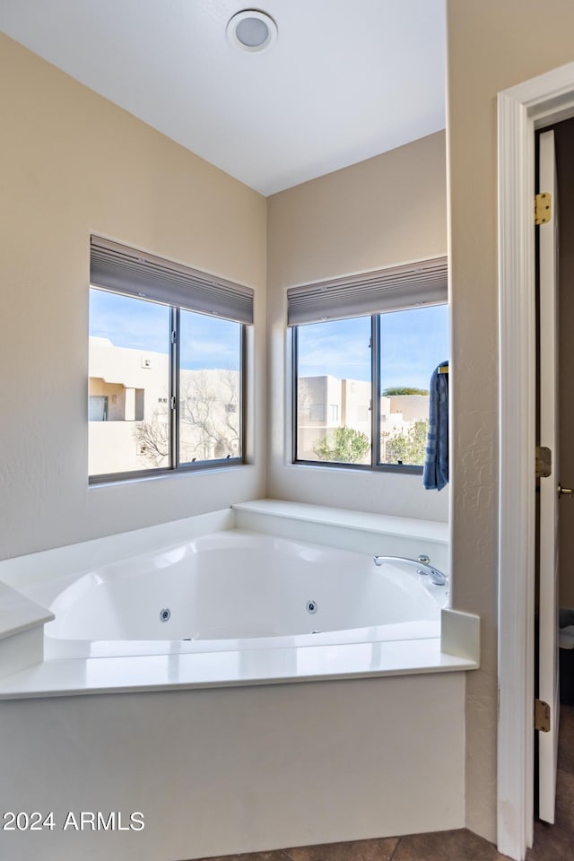 full bathroom with a tub with jets and a wealth of natural light