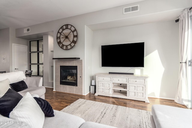 living room with dark wood-type flooring and a fireplace