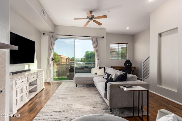 living room with dark wood-type flooring and ceiling fan