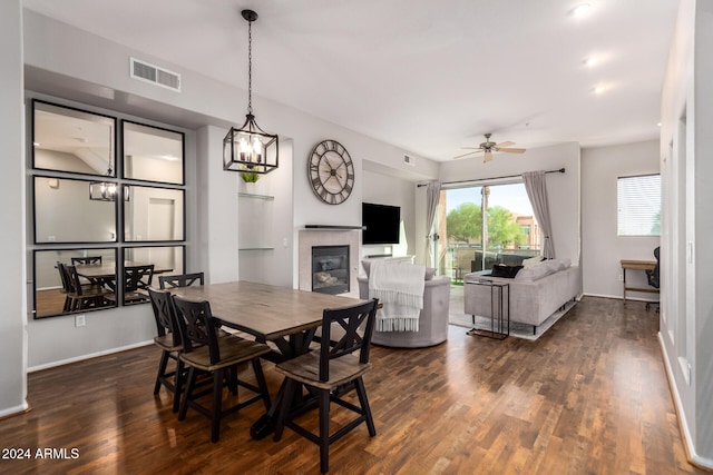 dining room with ceiling fan, dark hardwood / wood-style flooring, and a tile fireplace