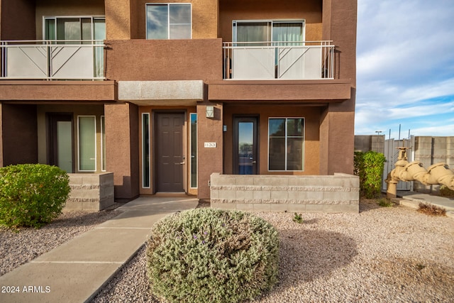 view of exterior entry with a balcony