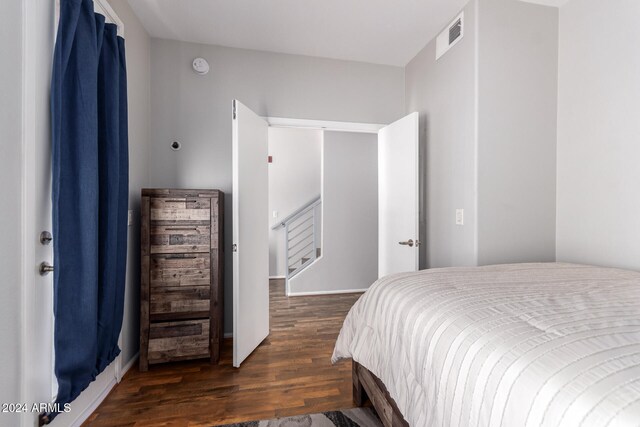 bedroom with dark hardwood / wood-style flooring