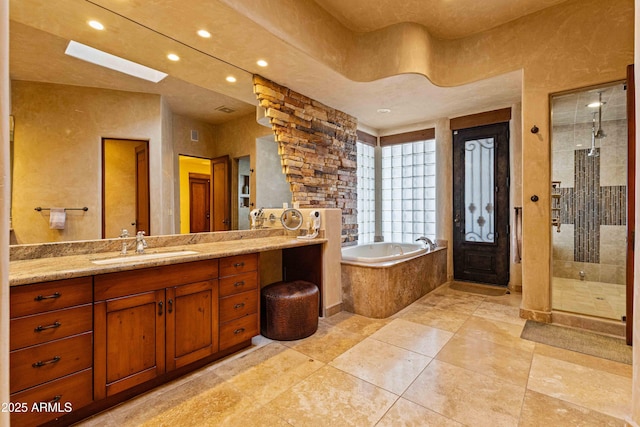 full bathroom featuring a garden tub, recessed lighting, a skylight, vanity, and a tile shower