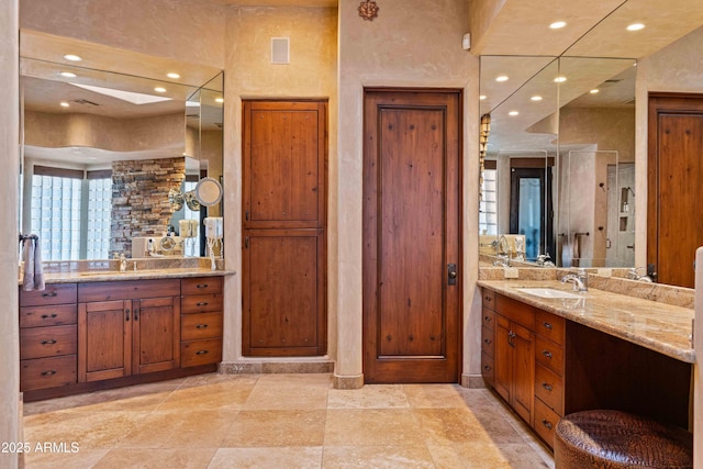 bathroom with a sink, two vanities, and recessed lighting