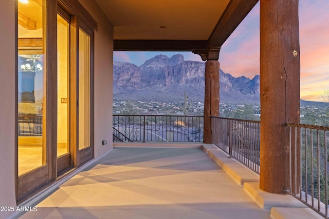 balcony at dusk featuring a mountain view