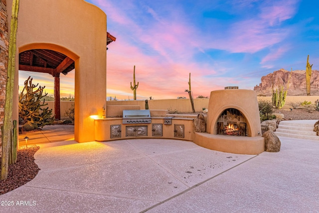 view of patio / terrace with exterior kitchen, fence, and grilling area