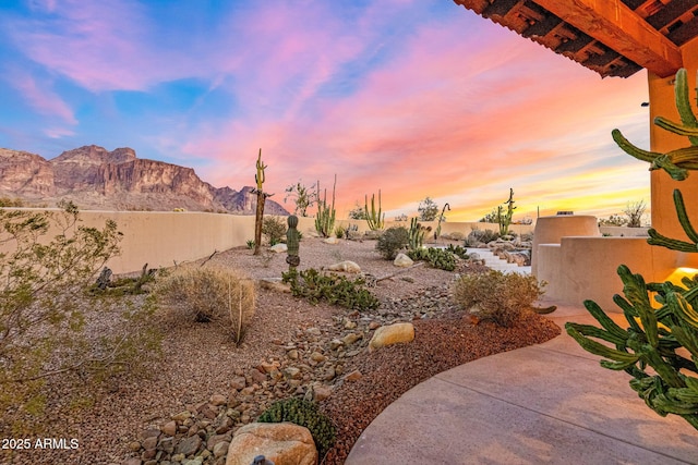 view of yard featuring a patio, fence, and a mountain view