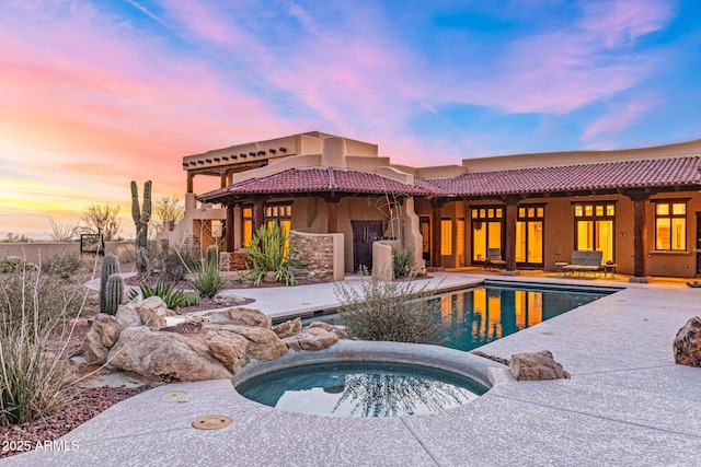 outdoor pool with a patio and an in ground hot tub