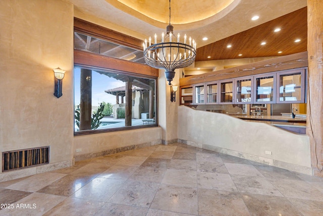 empty room featuring baseboards, visible vents, a chandelier, and recessed lighting