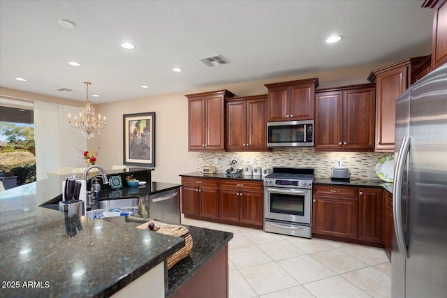 kitchen featuring tasteful backsplash, sink, dark stone counters, and appliances with stainless steel finishes