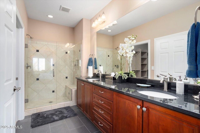 bathroom with vanity, a shower with door, and tile patterned floors