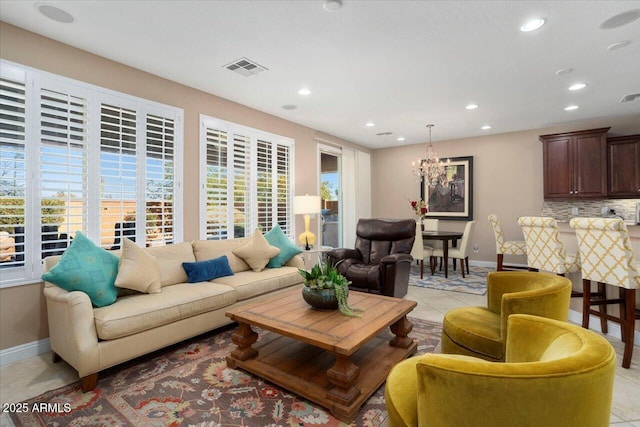 tiled living room featuring a notable chandelier