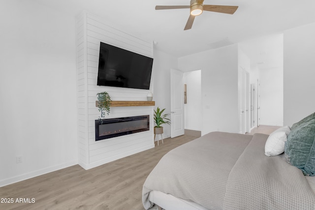 22634 E Roundup Way, Queen Creek, AZ 85142 - bedroom featuring a glass covered fireplace, wood finished floors, and ceiling fan