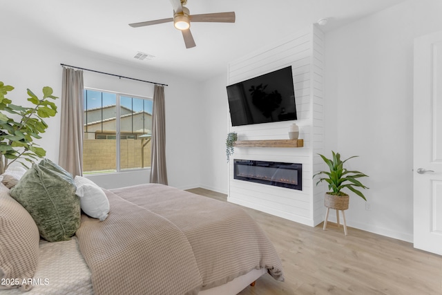 22634 E Roundup Way, Queen Creek, AZ 85142 - bedroom featuring wood finished floors, a fireplace, and ceiling fan