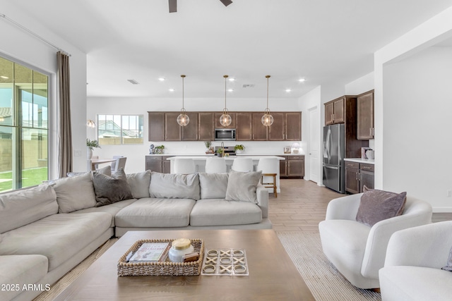 22634 E Roundup Way, Queen Creek, AZ 85142 - living room featuring a ceiling fan, recessed lighting, and light wood-style floors