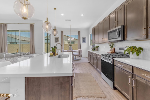 22634 E Roundup Way, Queen Creek, AZ 85142 - kitchen featuring stainless steel appliances, backsplash, plenty of natural light, a center island with sink, and recessed lighting
