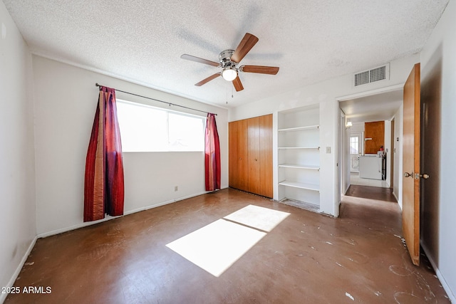 unfurnished bedroom featuring ceiling fan, a closet, concrete flooring, and a textured ceiling