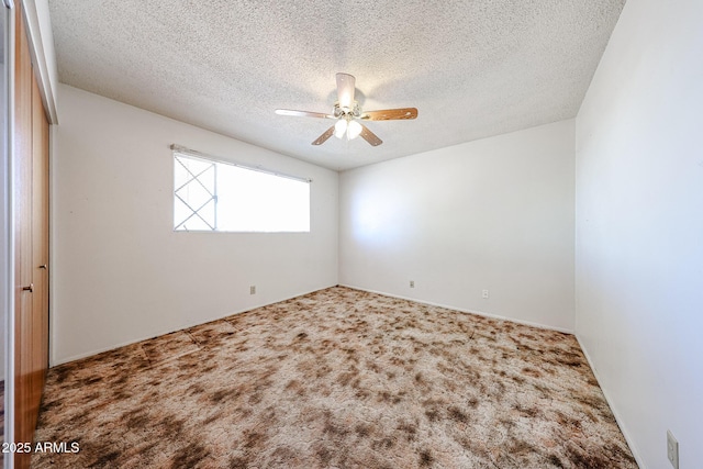 carpeted empty room featuring a textured ceiling and ceiling fan