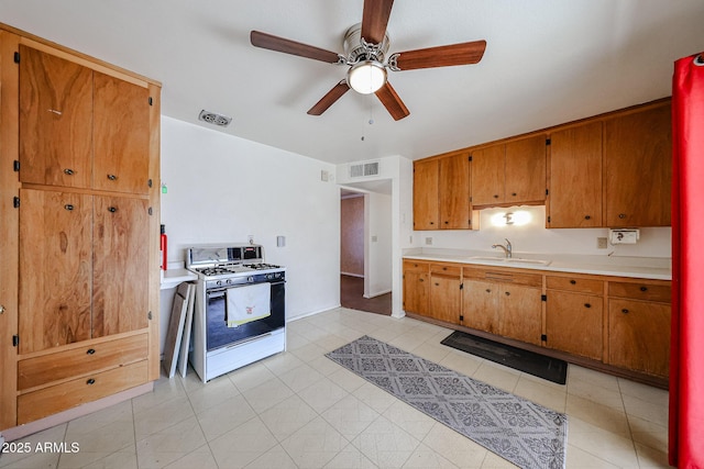 kitchen featuring ceiling fan, sink, and white range with gas stovetop