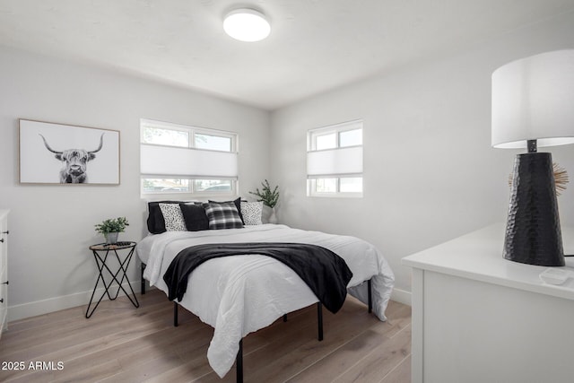 bedroom with light wood-type flooring and baseboards