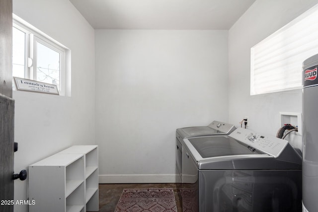 clothes washing area featuring laundry area, washing machine and dryer, baseboards, and a wealth of natural light