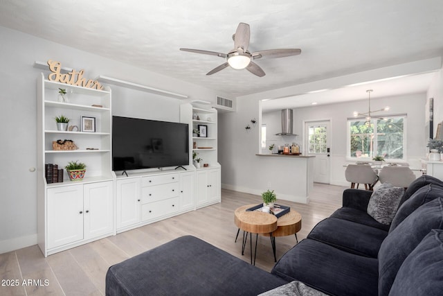 living area with baseboards, visible vents, light wood-type flooring, and ceiling fan