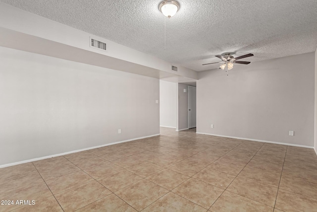 tiled spare room featuring a textured ceiling and ceiling fan