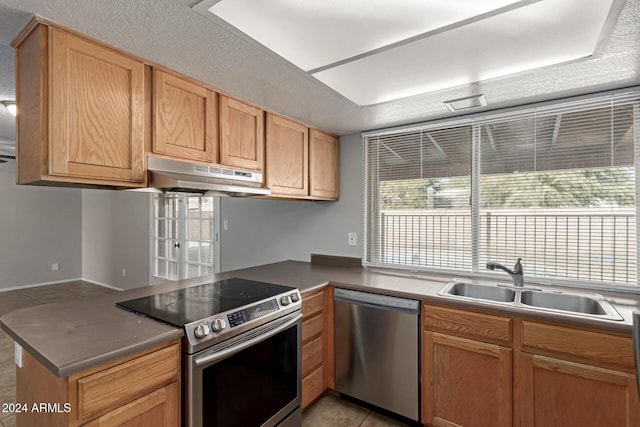 kitchen featuring kitchen peninsula, sink, light tile patterned flooring, and appliances with stainless steel finishes