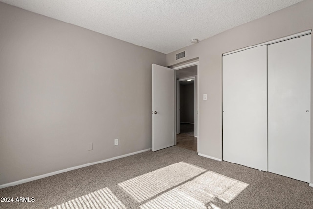 unfurnished bedroom with a closet, carpet floors, and a textured ceiling