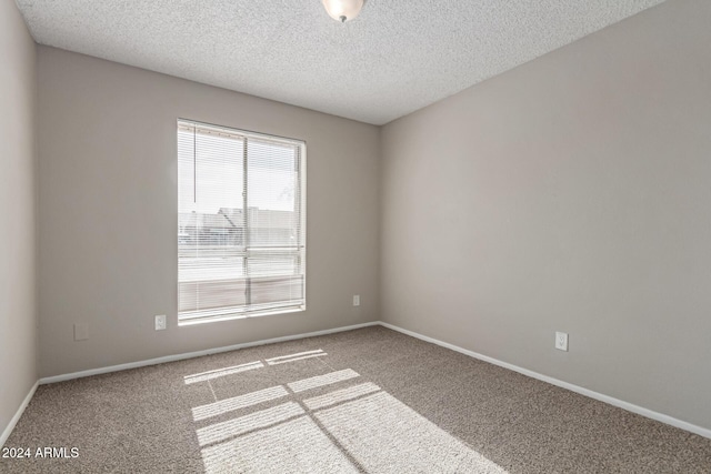 carpeted empty room featuring a textured ceiling