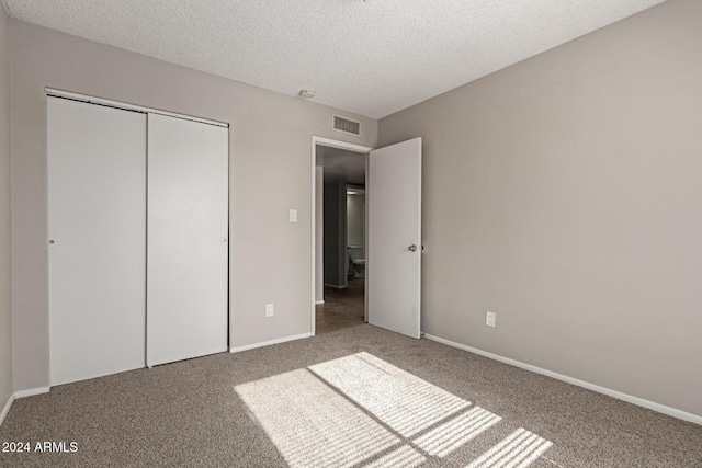 unfurnished bedroom featuring a closet, carpet floors, and a textured ceiling