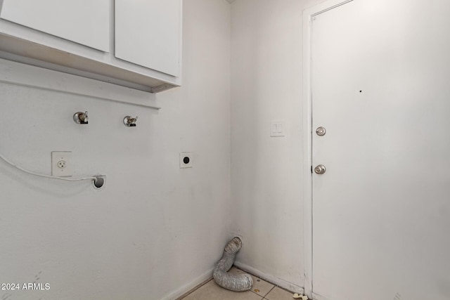 laundry area featuring hookup for an electric dryer, cabinets, and light tile patterned floors