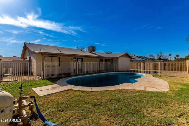 view of swimming pool featuring central AC unit and a lawn