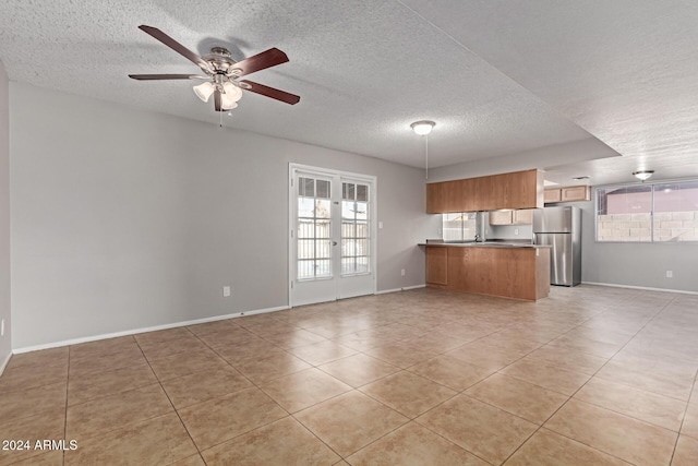 unfurnished living room with french doors, light tile patterned floors, and ceiling fan