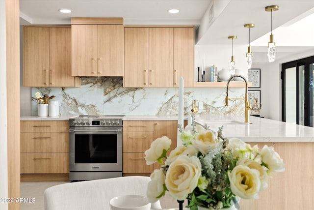 kitchen with electric range, light brown cabinets, sink, hanging light fixtures, and decorative backsplash