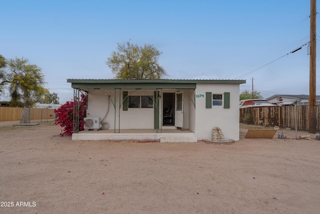 back of property featuring fence, ac unit, and stucco siding