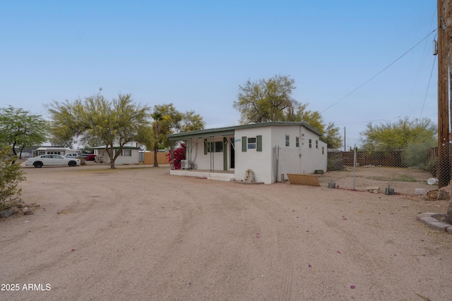 view of front of house featuring stucco siding, fence, and covered porch