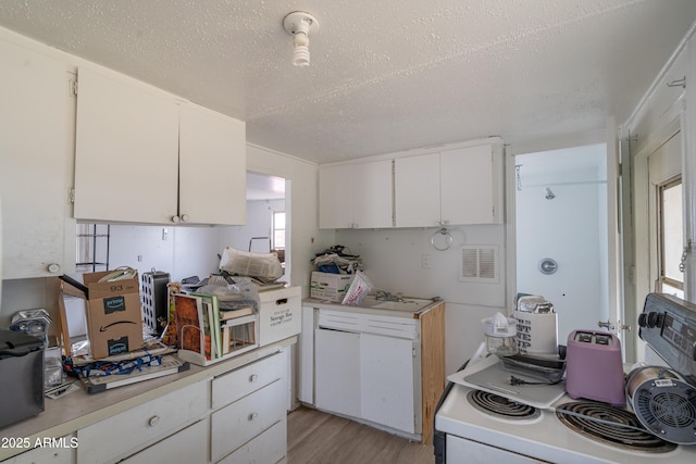 kitchen featuring white electric range oven, white cabinetry, light wood finished floors, and light countertops
