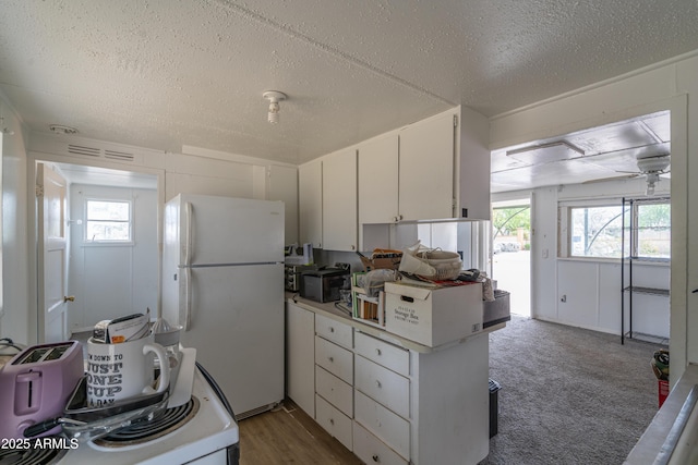 kitchen with light countertops, white cabinetry, white appliances, a textured ceiling, and ceiling fan