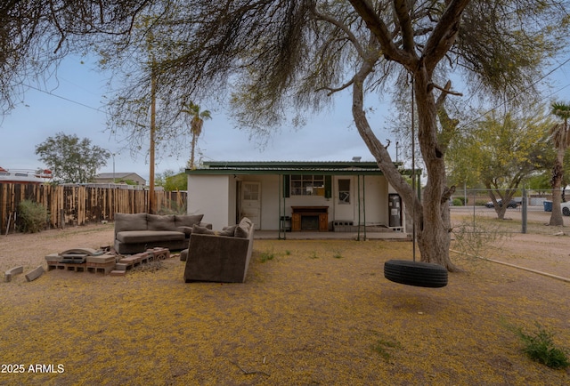 rear view of house with a fenced backyard, outdoor lounge area, and stucco siding