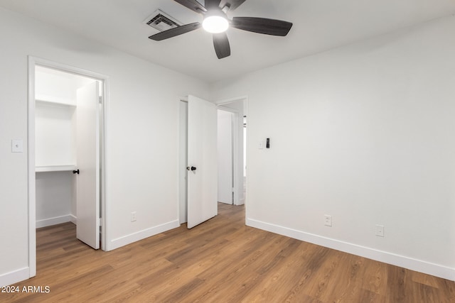 unfurnished bedroom with ceiling fan, light hardwood / wood-style flooring, and a closet