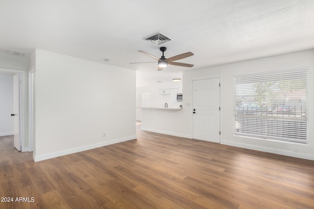 unfurnished living room featuring wood-type flooring and ceiling fan