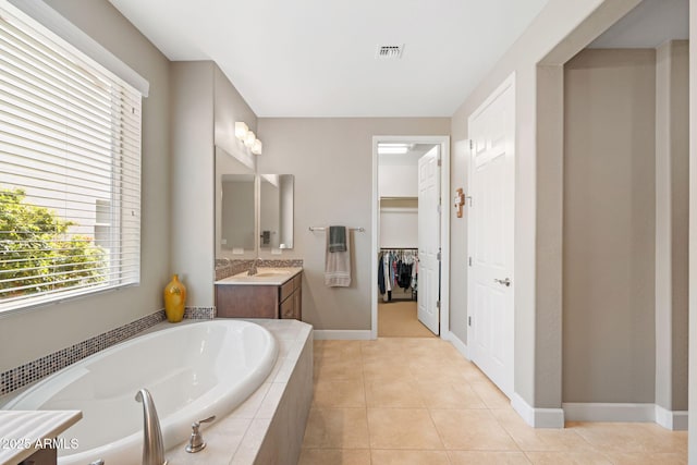 bathroom with vanity, tiled tub, and tile patterned floors