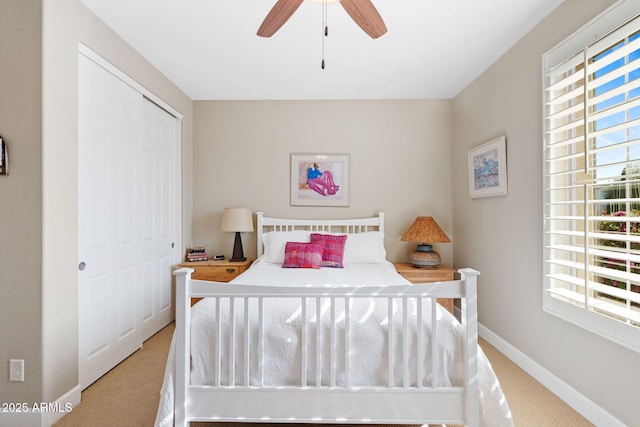 carpeted bedroom with multiple windows, ceiling fan, and a closet