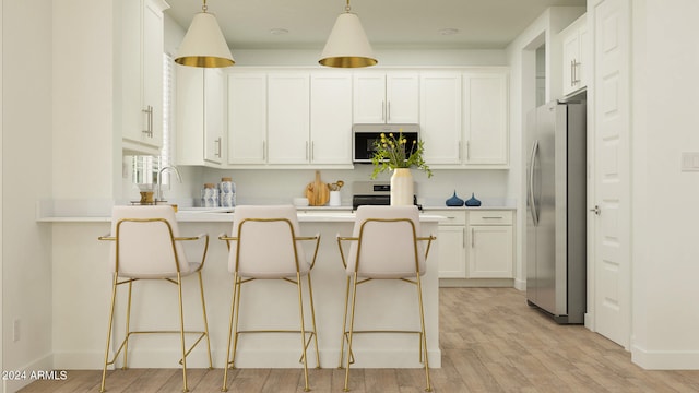 kitchen with white cabinetry, a kitchen bar, stainless steel appliances, light wood-type flooring, and hanging light fixtures