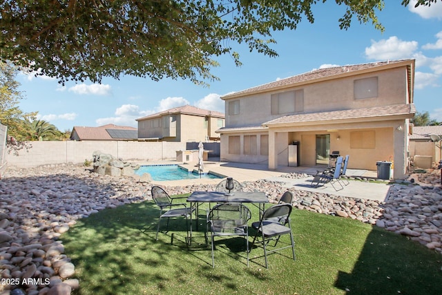 back of house featuring a fenced in pool, a yard, and a patio