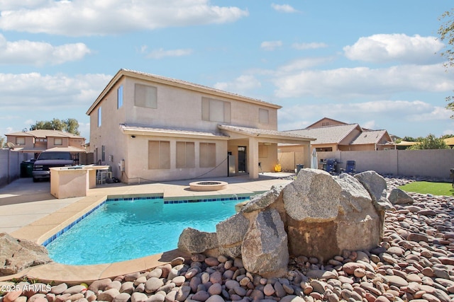 rear view of house featuring a patio area and a fenced in pool