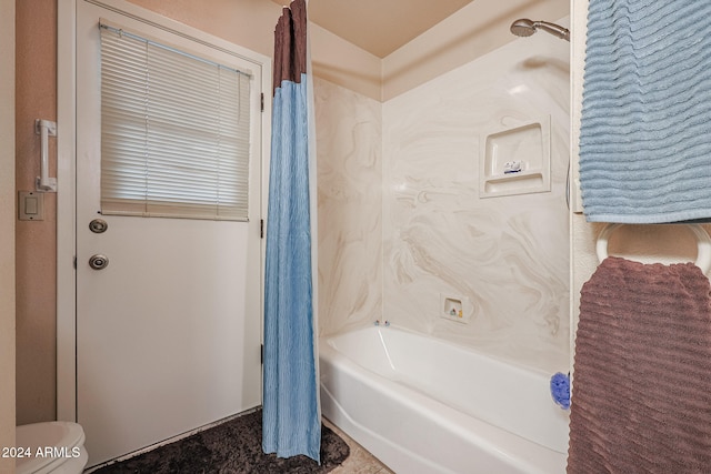 bathroom featuring shower / bath combination with curtain and toilet